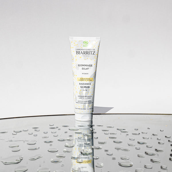 Radiance face scrub on surface with water drops